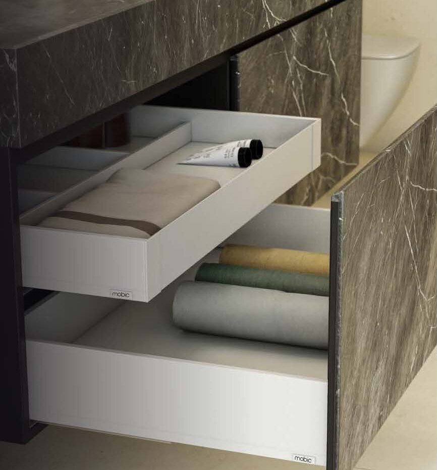 Cajones Next 4D blancos bajo un lavabo de mármol